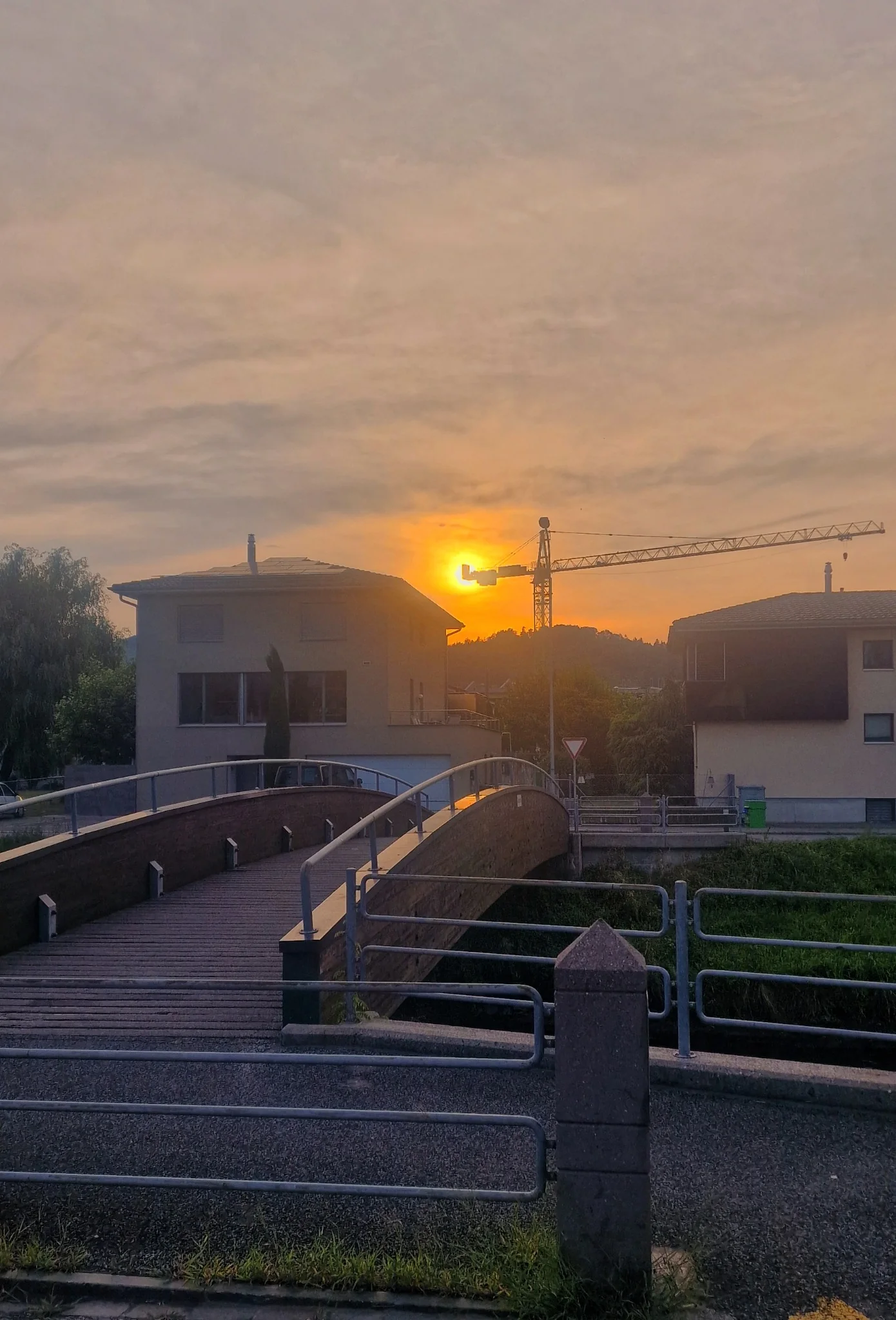 Sunset behind a crane and bridge